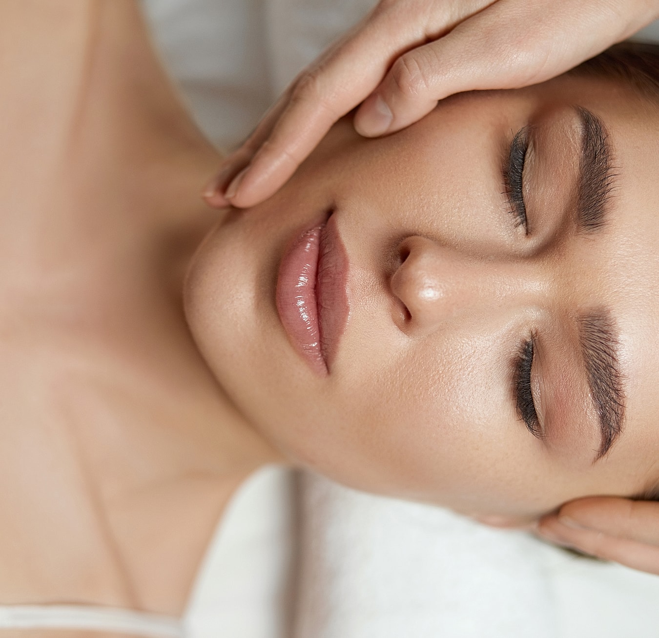 Woman receiving a facial massage in a spa.