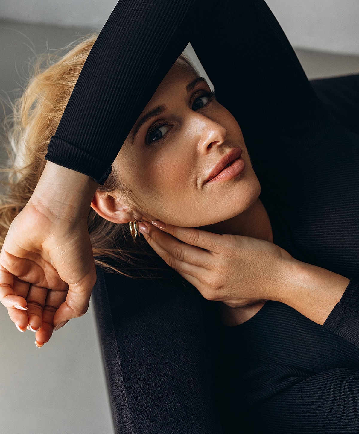 Woman with hands on her face, relaxed pose.