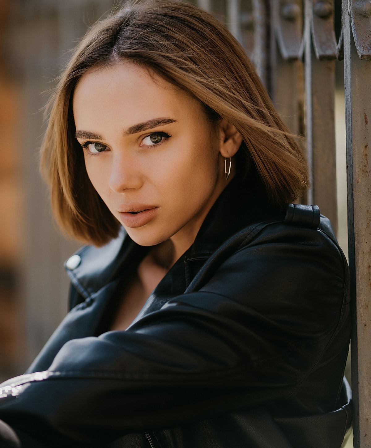 Woman in leather jacket with expressive gaze.