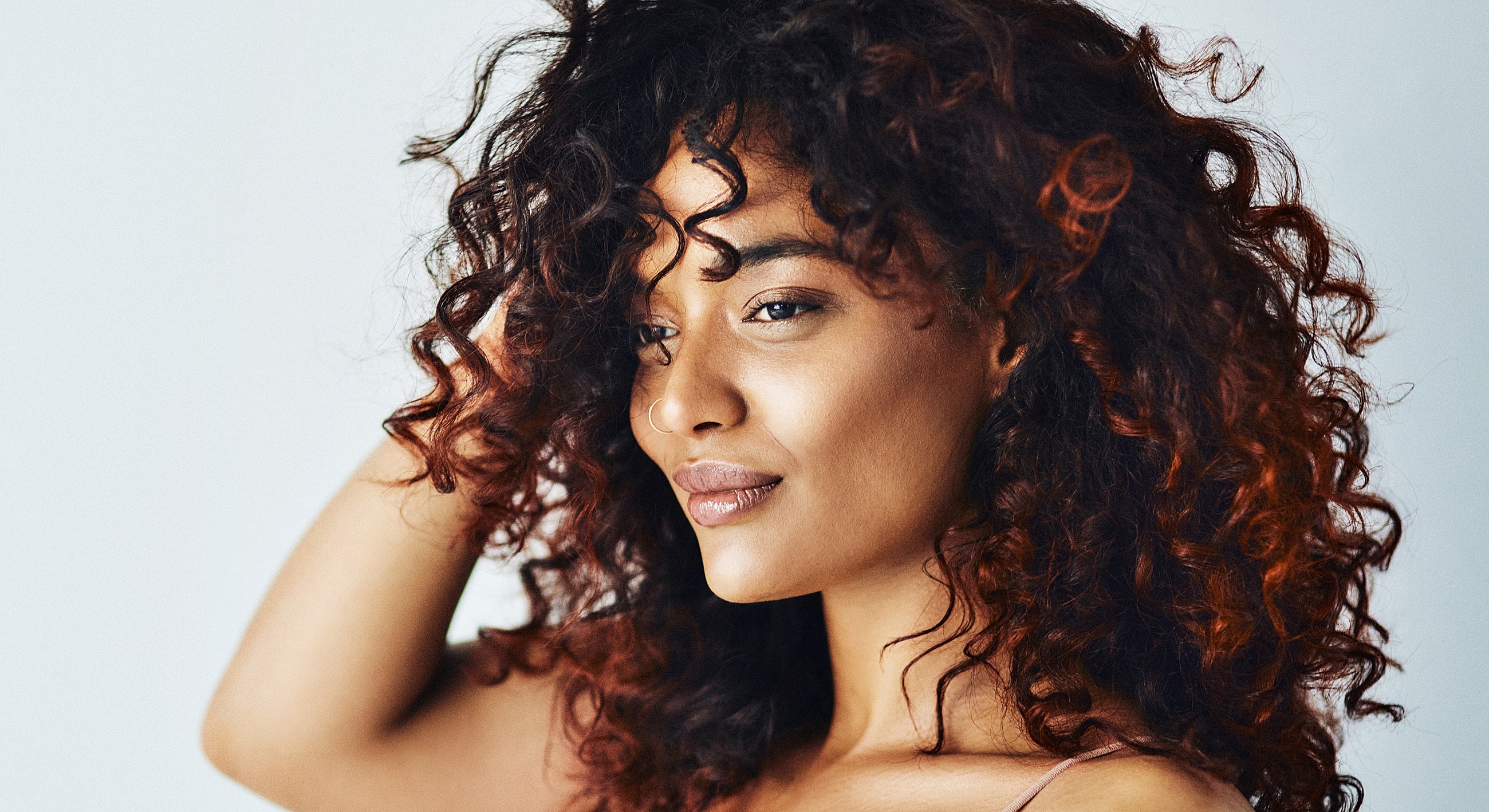 Woman with curly hair smiling softly.