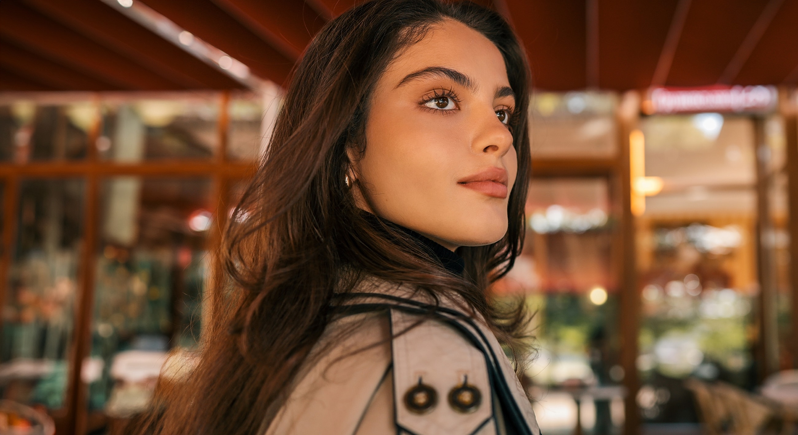 Young woman with long hair in café setting.