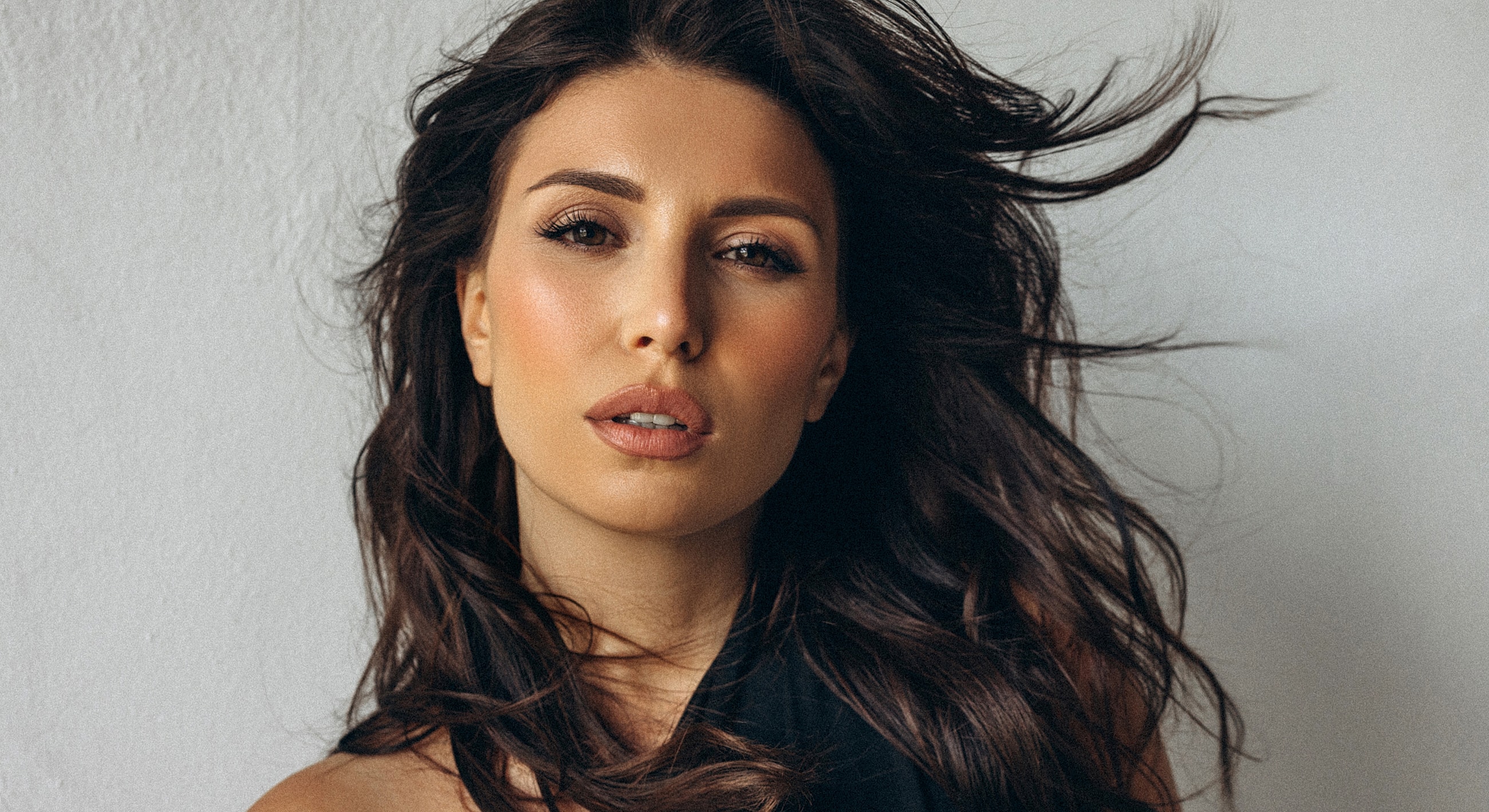 Woman with long hair against a light background.