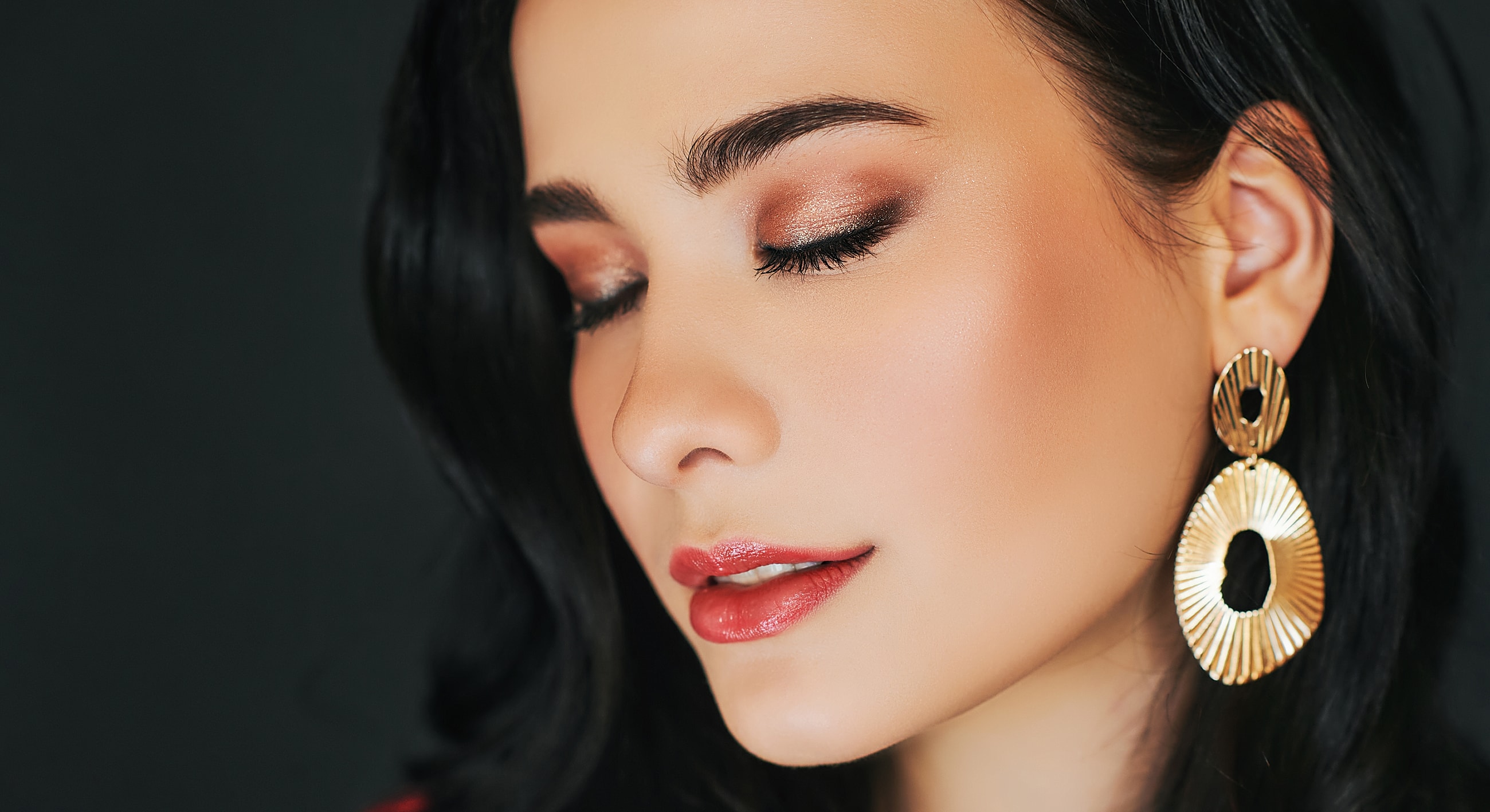 Woman with elegant makeup and statement earrings.